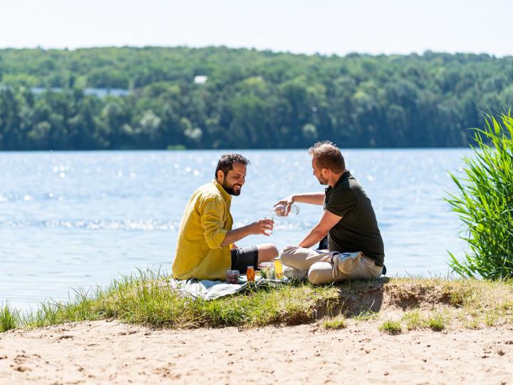 Zwei Männer picknicken am Wasser © Seenland Oder-Spree/Florian Läufer