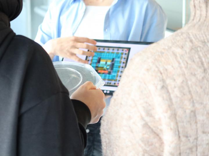 Forschung zum Anfassen: Während der Reinraumführung betrachten Schülerinnen einen Wafer aus der Nähe © IHP 2026/Juliane Schlegel